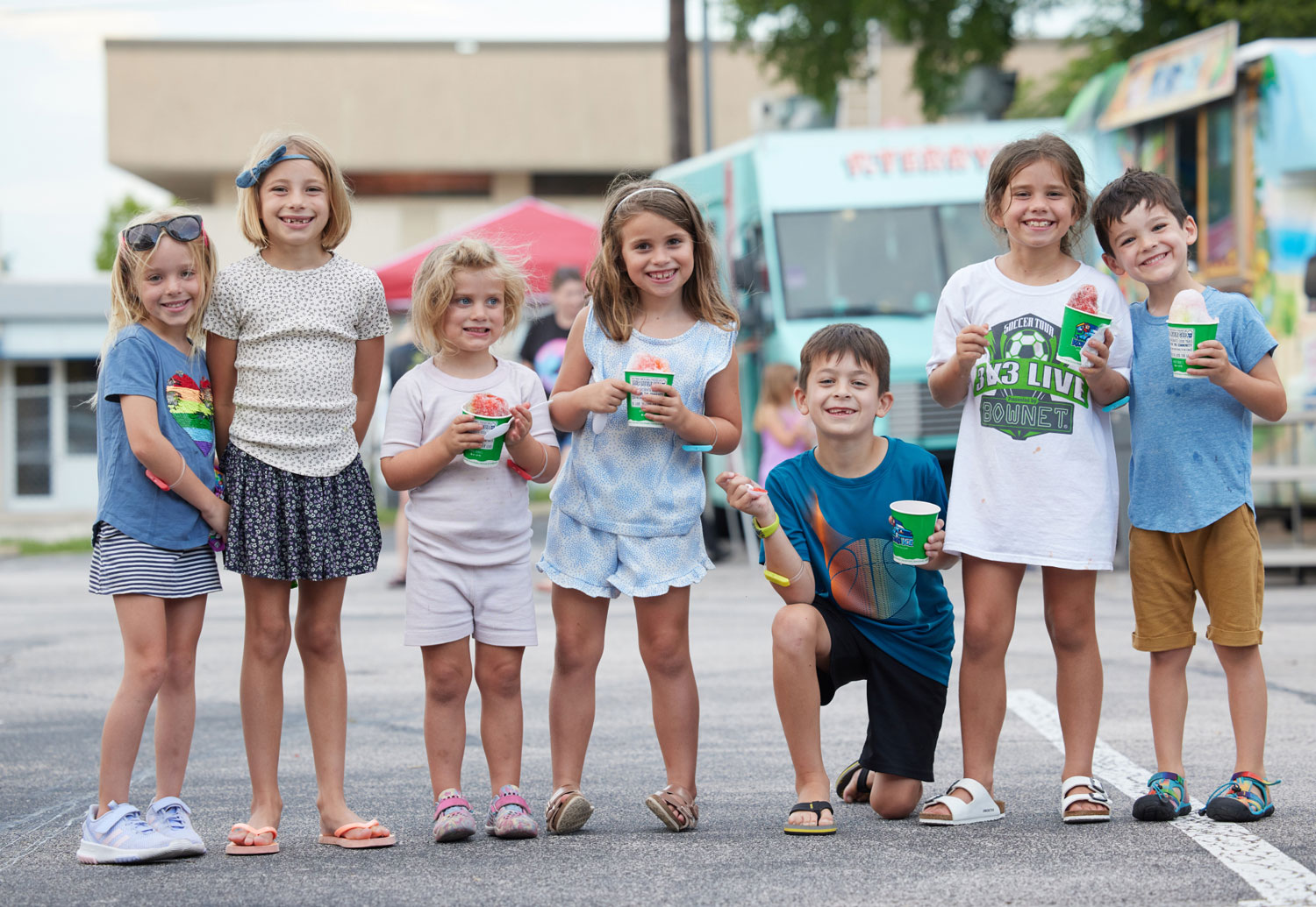A smiling group of children holding ice creams